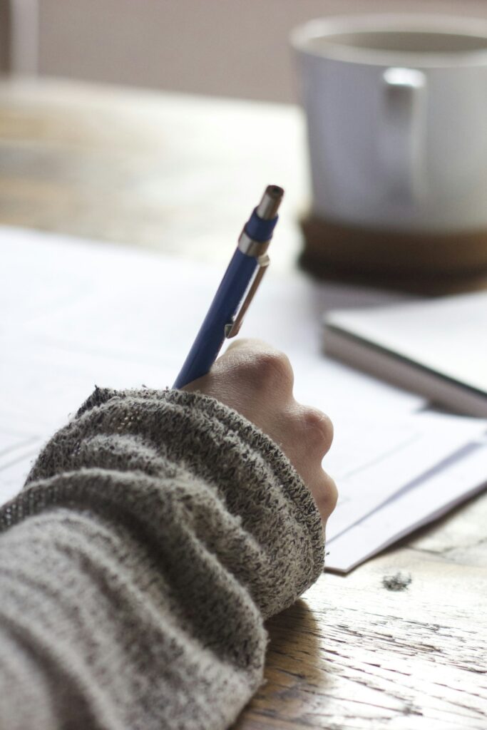Person writing blog content on a laptop for SEO