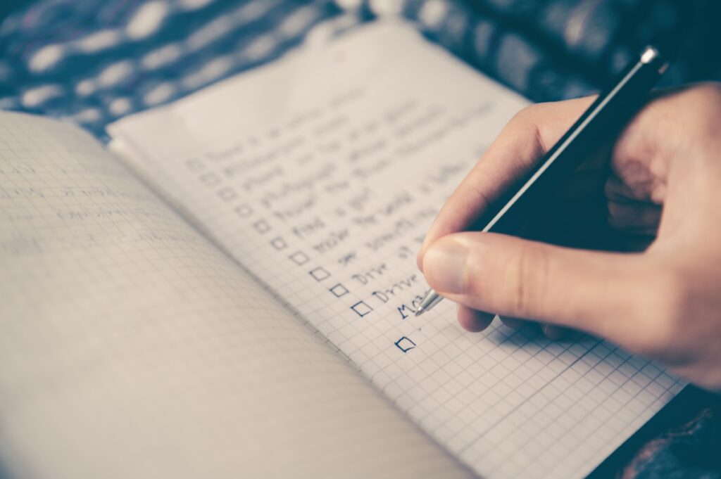 A wooden desk with a notebook calendar and pen for blog editorial calendar planning