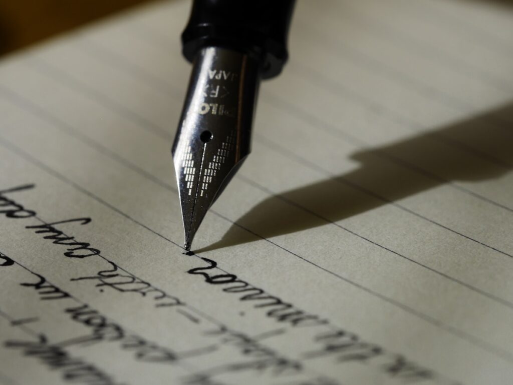 Person writing in a notebook for planning digital products for a blog