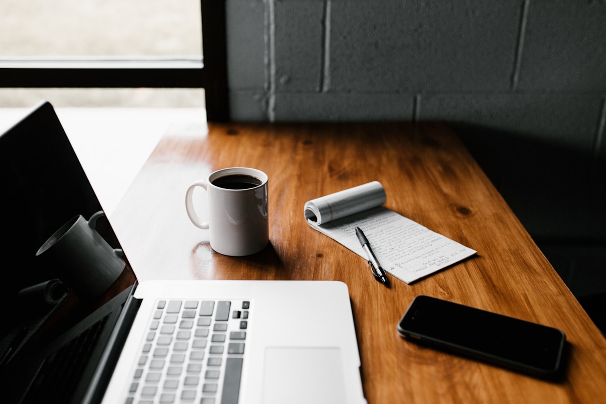 SEO for UK bloggers 2026 guide featuring a laptop on a desk with notebook and coffee